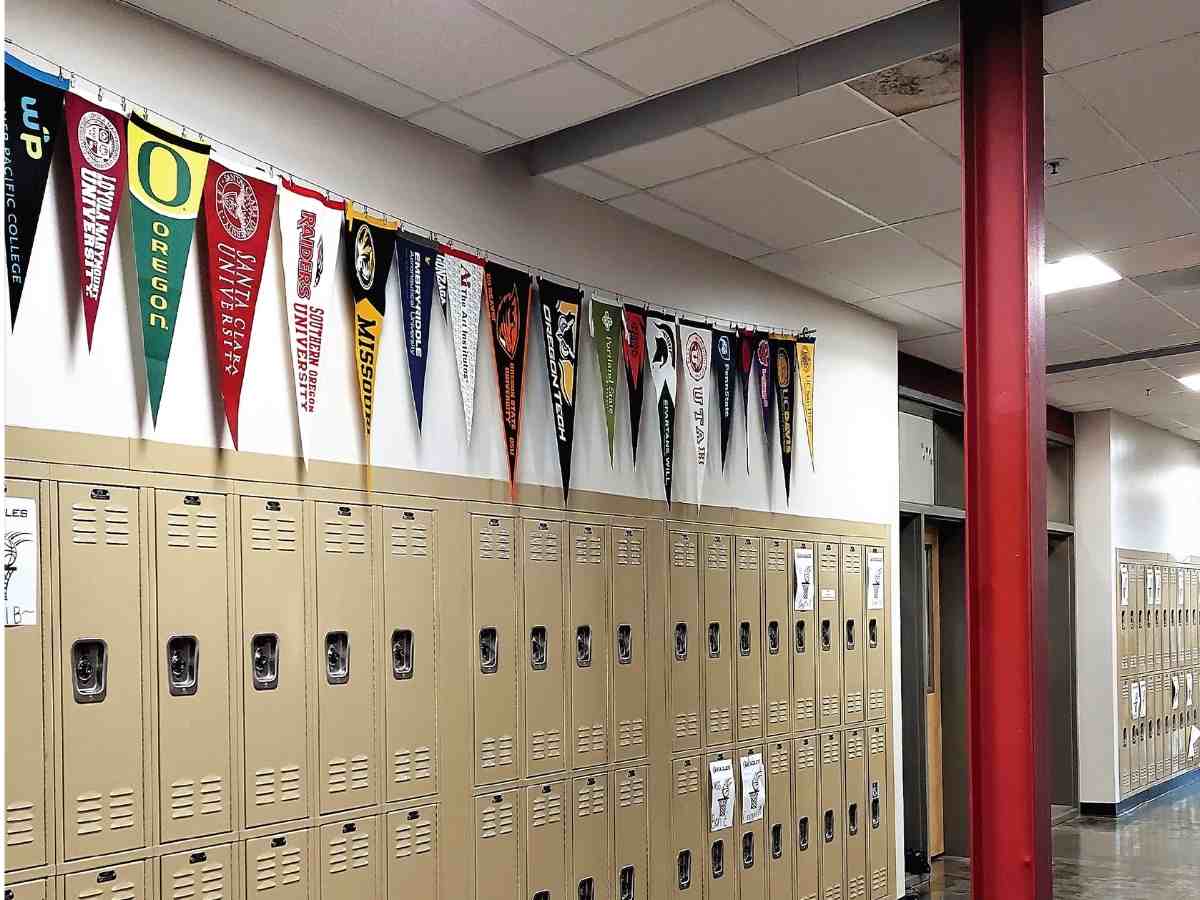 Hallway lined with lockers with college pendants from all kinds of schools hanging above the lockers for article Westside Christian High School for newcomers moving to Portland.
