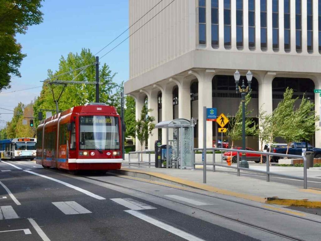 Red Streetcar pulling into NE 7th & Holladay stop for article Living in Downtown Portland for newcomers moving to Portland.