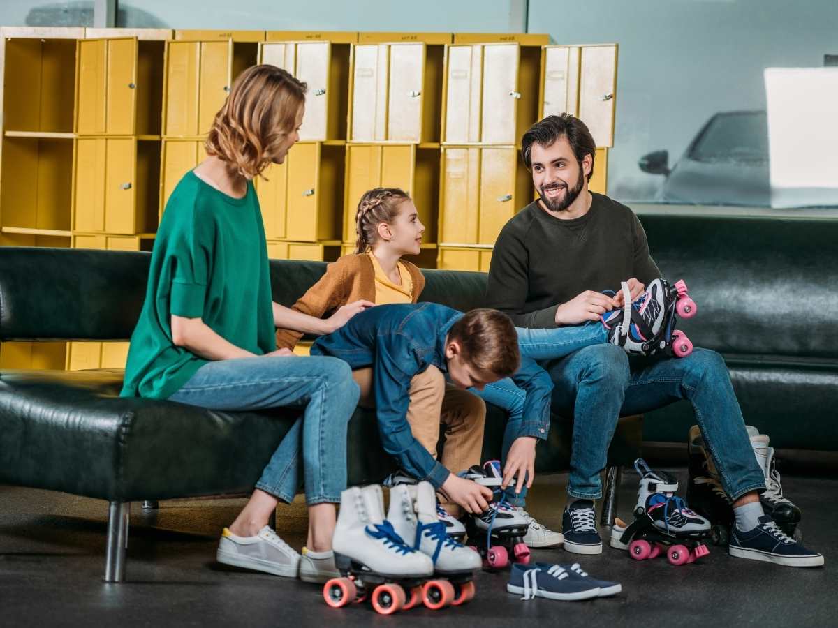 Mom, dad, boy and girl getting roller skates on feet for article 22 Fun Family Activities in Portland for newcomers moving to Portland.