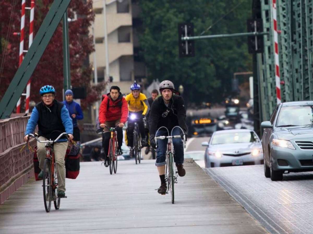 Group of people riding their bikes over bridge for article Navigate Like a Portland Native for newcomers moving to Portland.