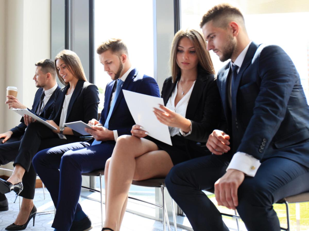 Recent grads sitting in office waiting to be called for job interview for article Land Your Dream Job in Portland for newcomers moving to Portland.
