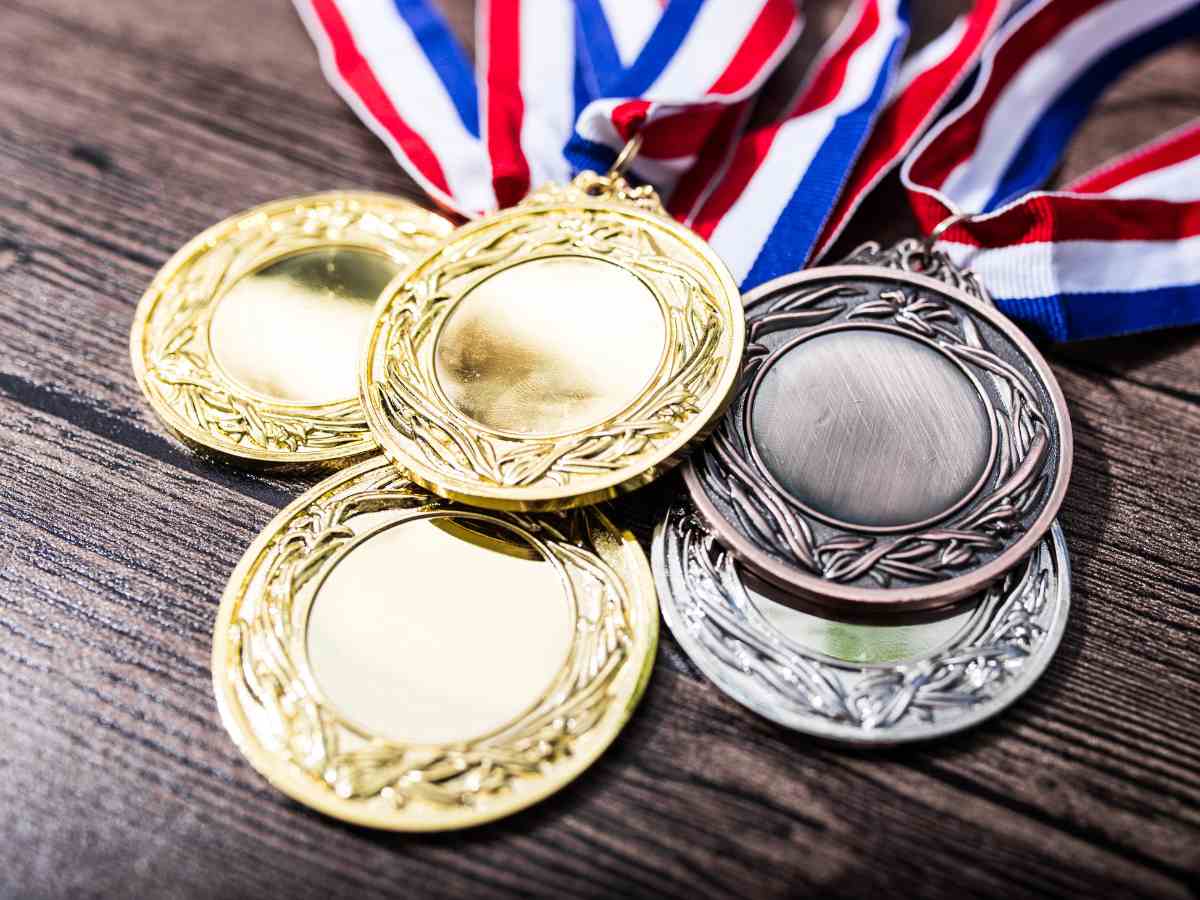 1st, 2nd, 3rd place medals stacked on table with red, white and blue ribbons attached for article Oregon's Olympic Stars: Homegrown Heroes for newcomers moving to Portland.