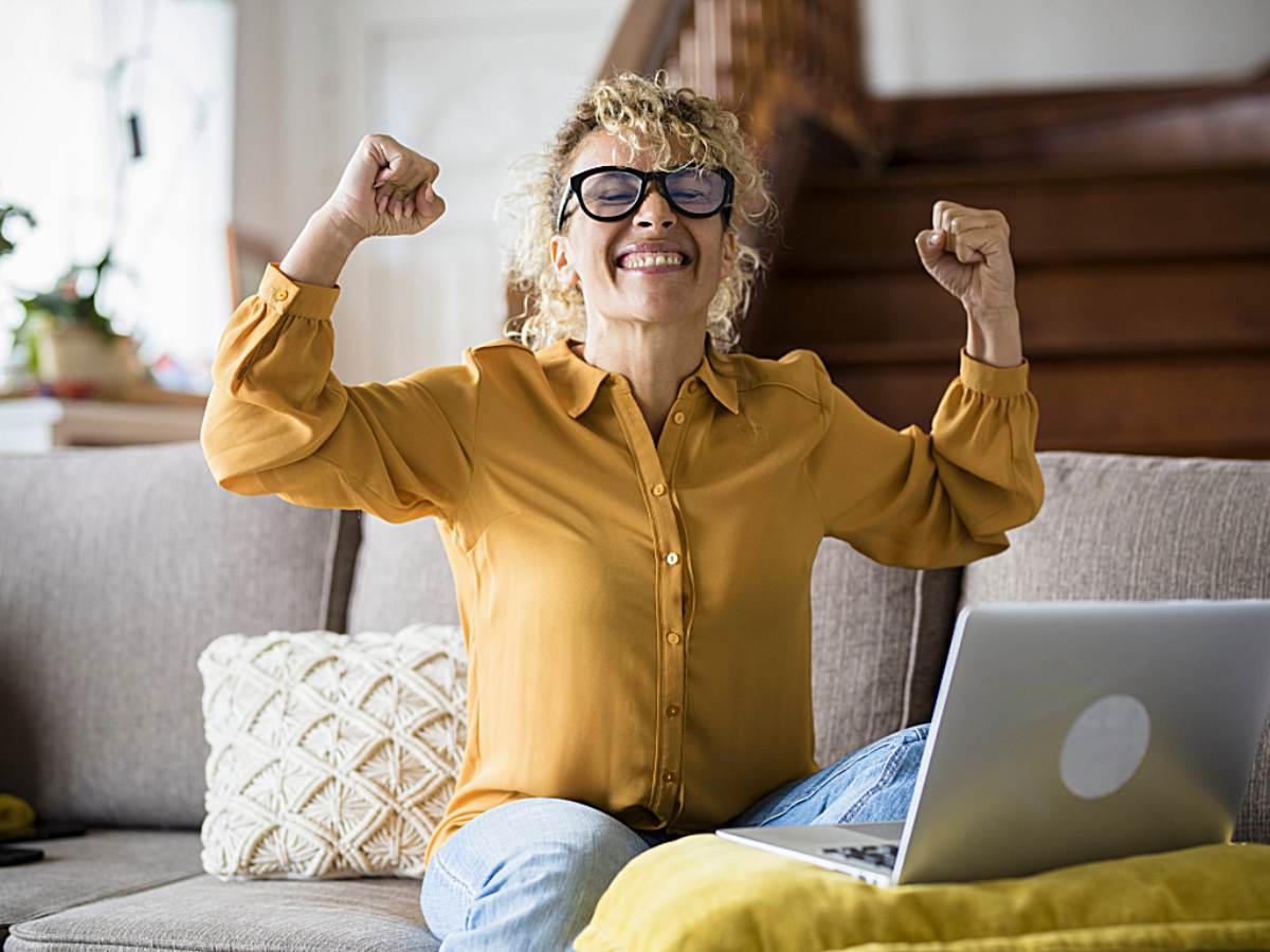Person celebrating in front of computer after finding contract work online for article Contract Work in Portland: A Guide for Relocating Professionals for newcomers moving to Portland.