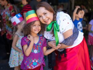 Woman leaning over and posing for camera with child for article Embrace the World for International School of Portland for newcomers moving to Portland.