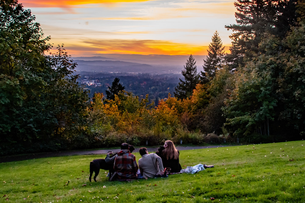 Couple watching sunset on a hill in Portland Couple watching sunset on a hill in Portland