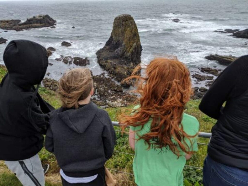 Cottonwood School students learning by place-based education out on the coast of Oregon overlooking the rocks and ocean for article How Charter and Magnet Schools in Portland Work for newcomers moving to Portland.