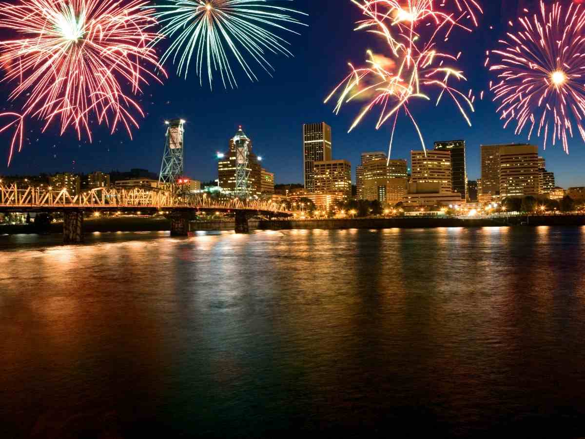 Fireworks over Portland bridge with skyline in background for article Best Places to Watch 4th of July Fireworks in Portland for newcomers moving to Portland area.