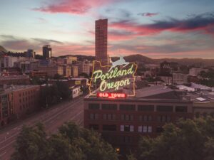 Porland Oregon light sign overlooking some buildings.