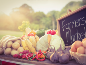 Fresh produce on a table with a chalkboard sign that says Farmers Market