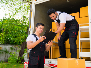 Professional movers moving boxes out of moving truck.