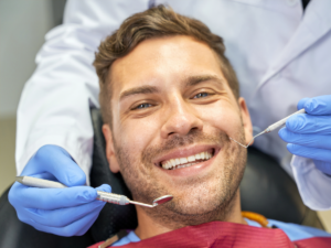 Male sitting in dentist chair smiling for article Discover 6 Trusted Dentists in Portland for newcomers moving to Portland.