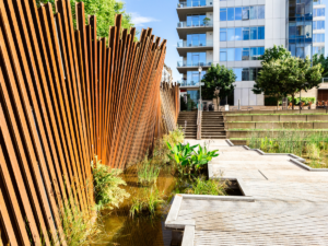 Unique fencing and walking path with modern apartments in backgound for article Discovering the Most Unique Neighborhood in Portland: Pearl District for newcomers moving to Portland.